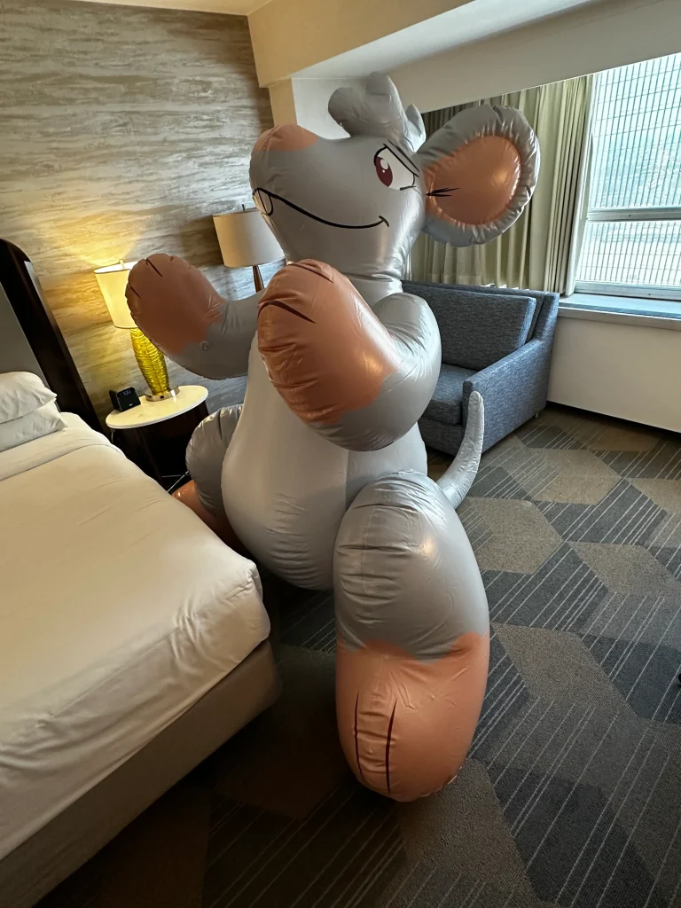 Grey and orange inflatable mouse indoors